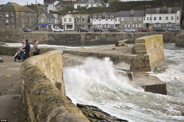 Người xem biển động trong bến cảng ở Porthleven, Cornwall, như Anh và xứ Wales phải đối mặt với một đập từ cơn bão tồi tệ nhất trong năm năm, dự báo thời tiết cảnh báo