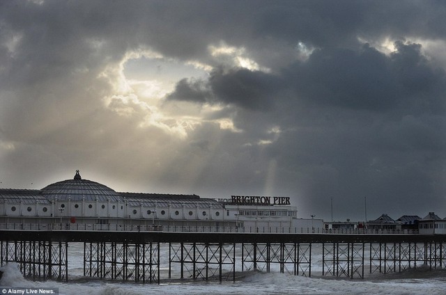 Bình tĩnh trước khi cơn bão: Một tia peeps ánh sáng mặt trời qua các đám mây nhìn tức giận về Bến tàu Brighton sáng hôm qua 