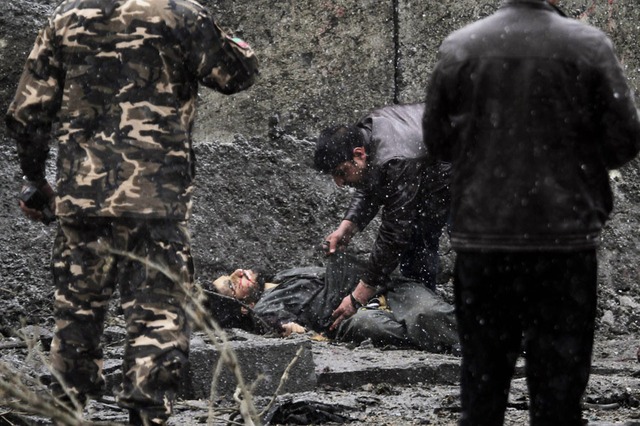 Nhân viên an ninh và tình báo Afghanistan kiểm tra một thi thể tại hiện trường vụ tấn công bới các phần tử Hồi giáo ở Kabul.