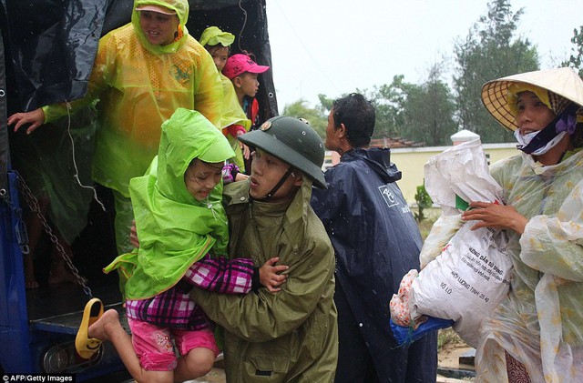 Một binh sĩ quân đội Việt Nam đưa bé gái khỏi chiếc xe tải khi người dân được sơ tán tới nơi an toàn.