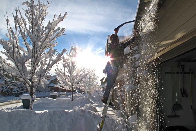 Một người dân cạo tuyết khỏi mái nhà ở Bellemont, bang Arizona, Mỹ.