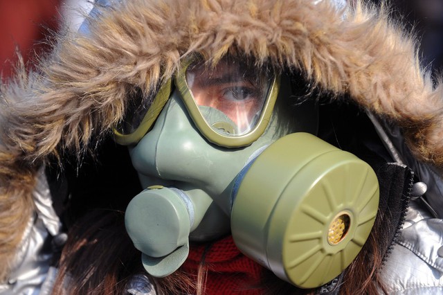Một phụ nữ đeo mặt nạ phòng khí độc trong khi tham gia biểu tình chống ô nhiễm không không khí ở Skopje, Macedonia.