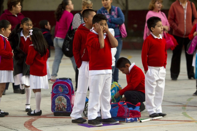Học sinh chờ trên sân trường để chờ vào lớp trong ngày đầu tiên của năm học mới ở Mexico City, Mexico.