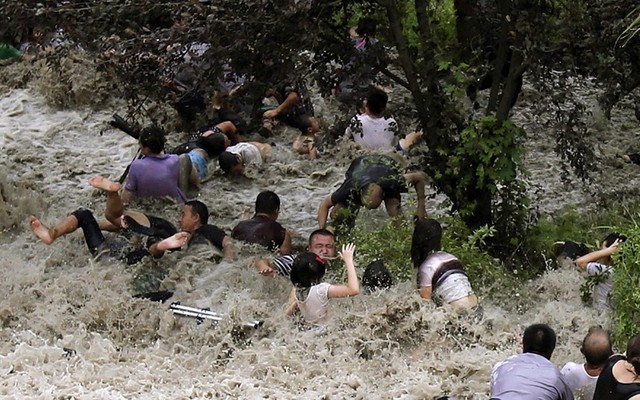 Triều cường kèm những đợt sóng khổng lồ của sông Tiền Đường ở tỉnh Chiết Giang của Trung Quốc, tràn qua con đê cuốn trôi nhiều người.