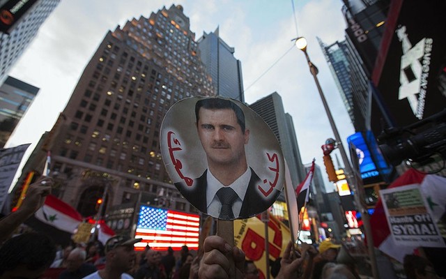Những người Mỹ gốc Syria và những người dân địa phương tham gia biểu tình ủng hộ Tổng thống al-Assad tại quảng trường Thời đại ở New York, Mỹ.