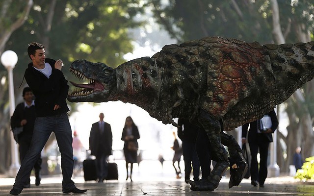 Nghệ sĩ hóa trang thành khủng long ăn thịt dọa người qua đường ở Sydney, Australia.