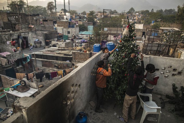 Người dân trang chí cây thông Giáng sinh tại một khu ổ chuột Islamabad, Pakistan.