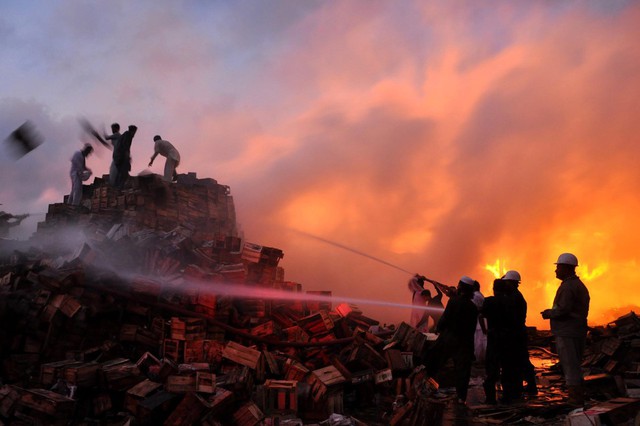 Lính cứu hỏa cố gắng dập tắt lửa bùng phát tại một khu chợ ở Karachi, Pakistan.