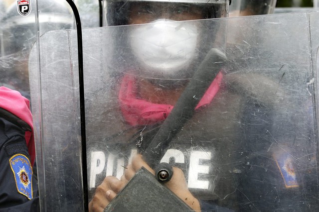 Cảnh sát chống bạo động đứng ngăn cản người biểu tình chống chính phủ ở Bankok, Thái Lan.