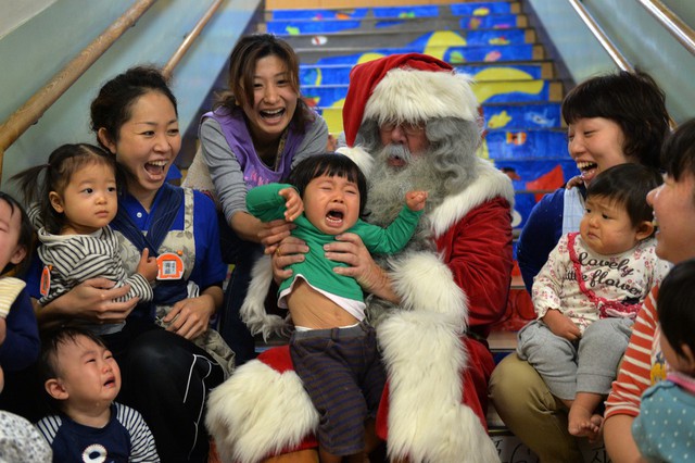 Các em bé khóc vì sợ khi chơi với ông già Tuyết tại Tokyo, Nhật Bản.