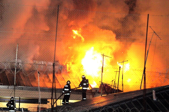 Lính cứu hỏa cố gắng lửa sau khi hỏa hoản xảy ra tại nhà tù Quillota ở Chile.