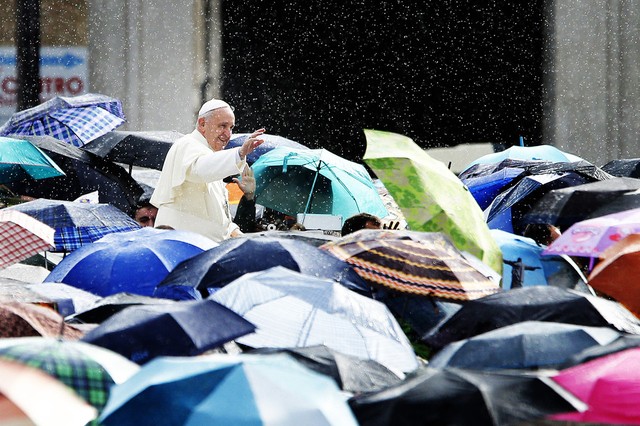 Giáo hoàng Francis chào mọi người đứng dưới mưa trên quảng trường St. Peter ở Vatican.