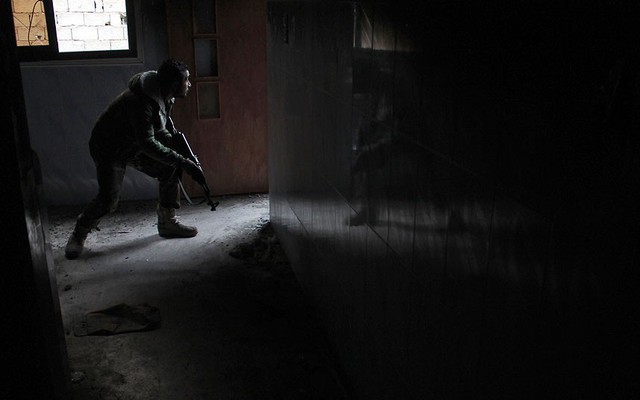 Một chiến binh phiến quân chiến đấu với quân đội chính phủ ở thành phố Deir Ezzor, Syria.