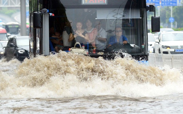 Xe bus đi trên đường phố ngập lụt ở thành phố Vũ Hán thuộc tỉnh Hồ Bắc, Trung Quốc.