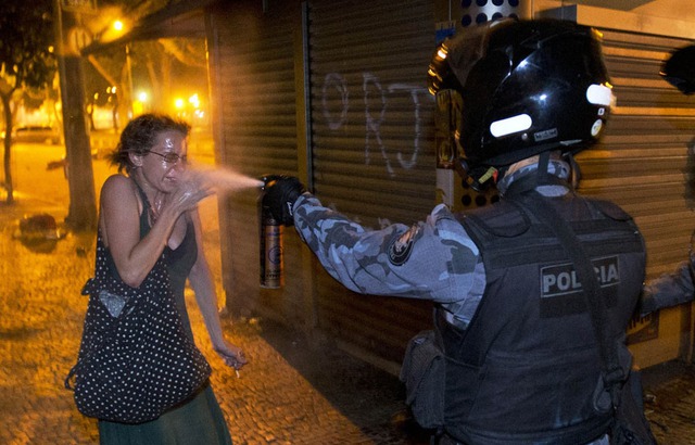 Cảnh sát quân sự xịt hơi cay vào một người biểu tình Rio de Janeiro, Brazil.