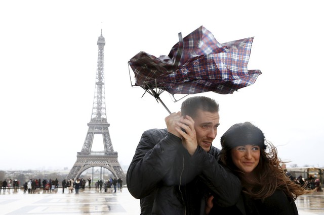 Một cặp đôi đi dưới trời mưa và gió mạnh tại thành phố Paris, Pháp. Mưa bão đã gây ách tắc giao thông và mất điện tại nhiều thành phố ở Pháp.