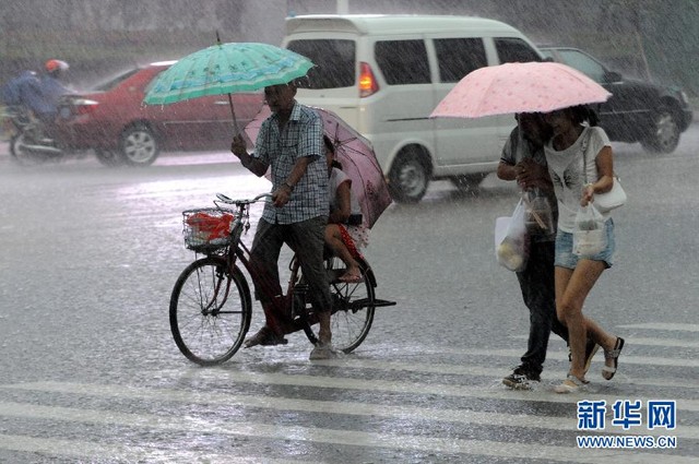 Người dân hối hả đi dưới trời mưa lớn ở thành phố Quỳnh Hải, tỉnh Hải Nam.