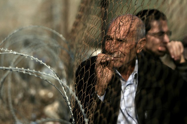 Những người Palestin đang đứng chờ để vào Ai Câp qua biên giới ở Dải Gaza.