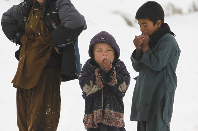 Trẻ em đứng co ro trên tuyết ở Kabul, Afghanistan.