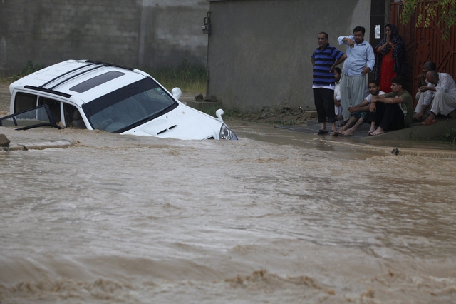 Một chiếc xe hơi bị chết máy khi đang di chuyển trên đường phố ngập lụt ở ngoại ô Karachi, Pakistan.