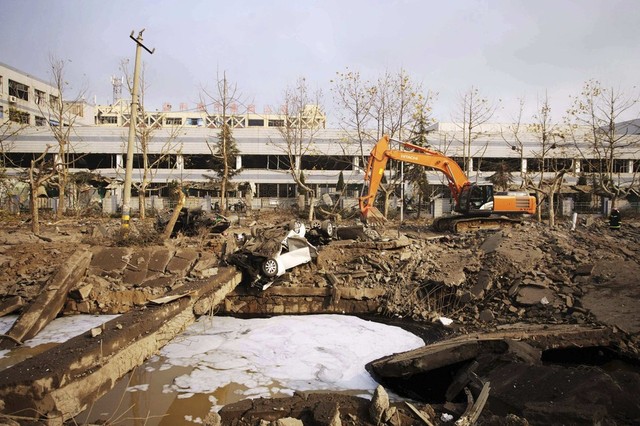 Máy xúc dọn dẹp đống đổ nát sau khi đường ống dẫn dầu phát nổ làm 35 người thiệt mạng ở Thanh Đảo, Sơn Đông, Trung Quốc.