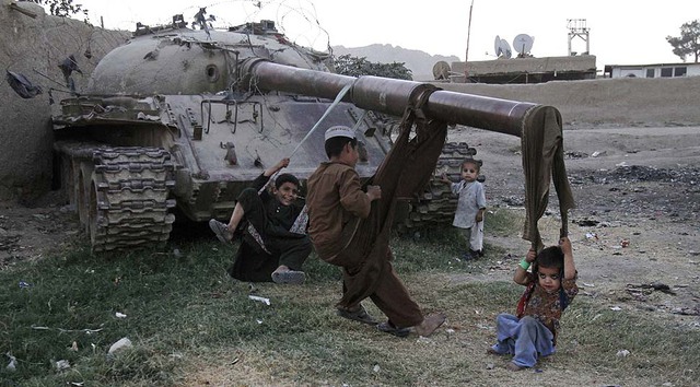 Trẻ em chơi trên một chiếc xe tăng Liên Xô cũ ở Kabul, Afghanistan.