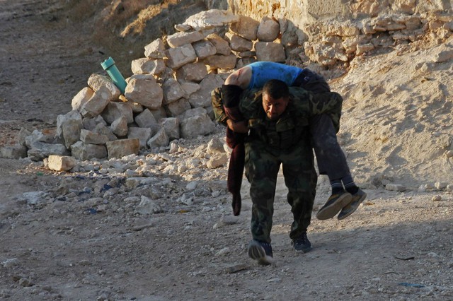 Chiến binh phiến quân Syria vác thi thể một đồng đội thiệt mạng trong cuộc giao tranh với quân đội chính phủ ở thành phố Aleppo.