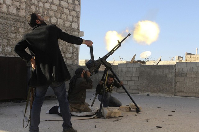 Các chiến binh phiến quân xả súng máy nhằm vào một máy bay trực thăng của quân đội chính phủ Aleppo, Syria.