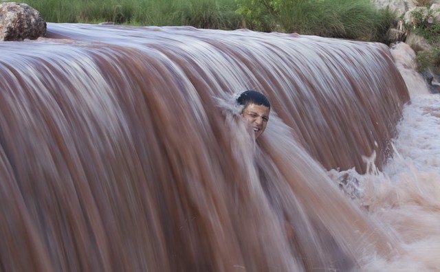 Một cậu bé tắm dưới dòng suối sau mưa lớn ở ngoại ô thành phố Islamabad, Pakistan.