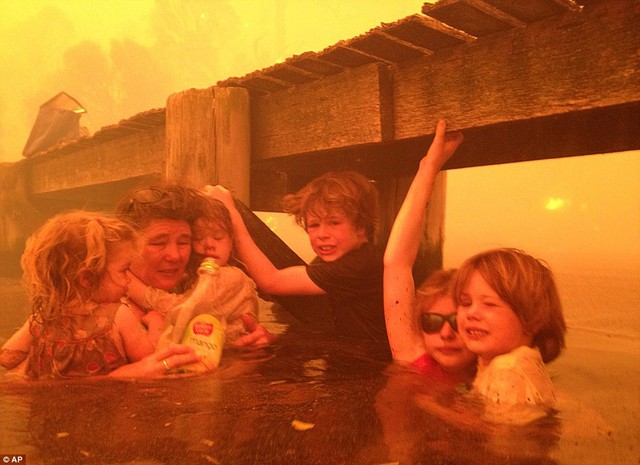 Cô Tammy Holmes và những đứa con trú dưới một cầu tàu khi cháy rừng quét qua khu vực Tasmania, Australia.