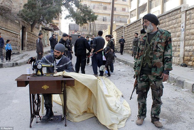 
	Chiến binh Syria ngồi may quần áo ngay giữa phố.