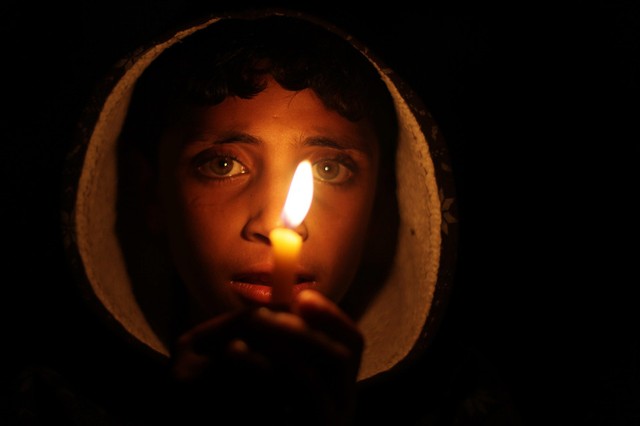 Một cậu bé cầm cây nến trong khi tham gia biểu tình phải đối tình trạng mất điện ở thành phố Gaza. Nhà máy phát điện duy nhất tại thành phố này đã phải ngừng hoạt động do thiếu nhiên liệu.