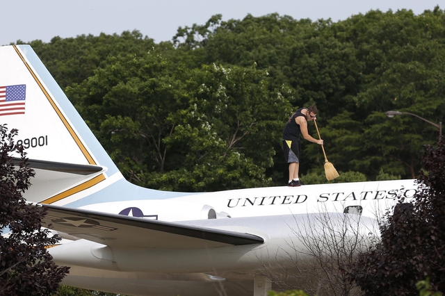 Một nhân viên quét dọn trên thân mô hình chuyên cơ Air Force One tại căn cứ Andrews ở bang Maryland, Mỹ. Chuyên cơ Air Force One được sử dụng để chở Tổng thống Mỹ.