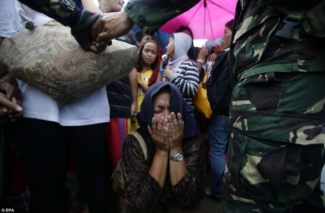 Một phụ nữ òa khóc khi bị các binh sĩ ngăn lại.