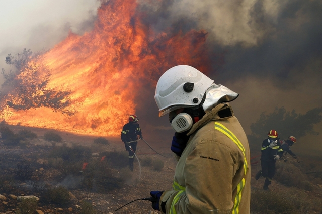 Lính cứu hỏa tham gia dập tắt lửa tại một đám cháy rừng ở Marathon, Hi Lạp.