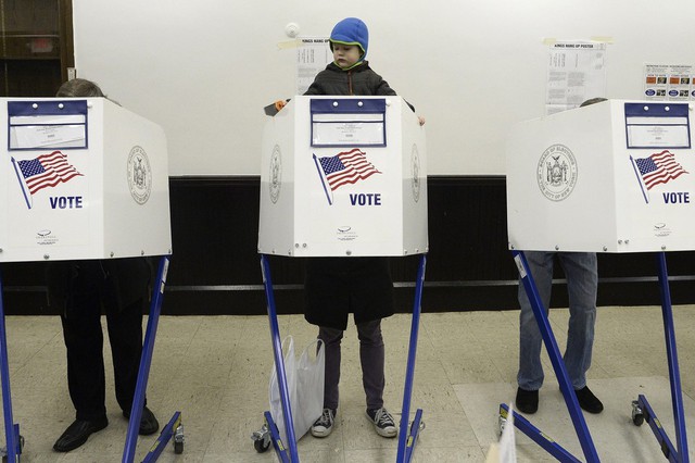 Cậu bé Merritt Tucker ngồi trên vai mẹ đang bỏ phiếu bầu thị trưởng tại một điểm bầu cử ở New York, Mỹ.