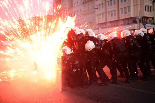 Các cảnh sát chống bạo động ẩn nấp trong cuộc đụng độ với người biểu tình ở Istanbul, Thổ Nhĩ Kỳ.