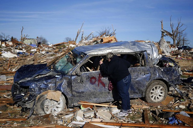 Một phụ nhìn vào trong chiếc ô tô bị tàn phá bởi lốc xoáy ở Washington, Mỹ.