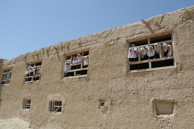 Các nữ sinh nhìn ra ngoài cửa sổ các lớp học tại một trường học ở tỉnh Ghazni, Afghanistan.