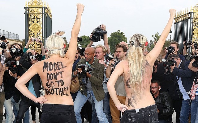 Những thành viên của nhóm Femen biểu tình ngực trần trước lối vào buổi trình diễn thời trang của nhà thiết kế Nina Ricci tại Tuần lễ thời trang Paris, Pháp.