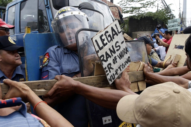 Công nhân xô xát với cảnh sát và lực lượng an ninh trong cuộc biểu tình đòi tăng lương bên ngoài một nhà máy thép ở Quezon, Philippines.
