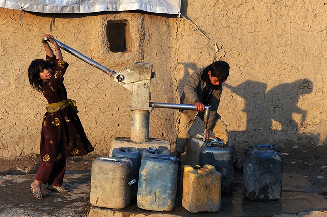 Một bé gái bơm nước từ giếng khoan trong một trại tị nạn ở thủ đô Kabul, Afghanistan.