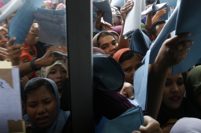 Mọi người xô đẩy nhau trong khi cố gắng nộp đơn xin thi công chức tại tỉnh Aceh, Indonesia. Khoảng 25.000 người nộp đơn vào 193 vị trị trong chính quyền của tình này.