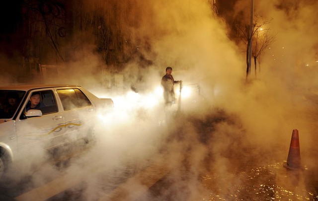 Xe ô tô đi qua đoạn đường bao phủ đầy hơi nước sau khi đường ống dẫn nước nóng bị vỡ ở Thái Nguyên, Trung Quốc.