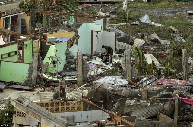 Người đàn thu lượm những thứ còn dùng được trong ngôi nhà bị bão tàn phá ở Tacloban.