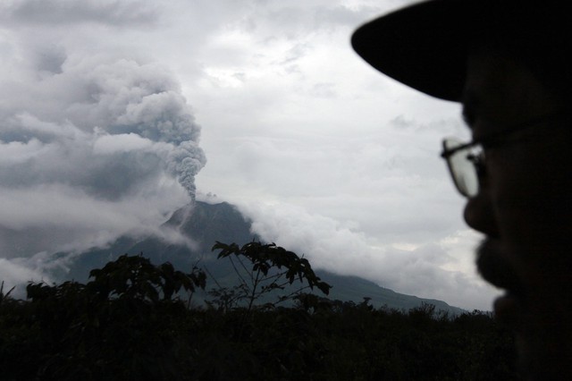 Người dân đứng nhìn núi lửa Sinabung phun trào ở Simpang Empat, Indonesia.