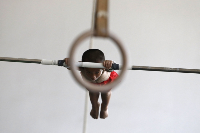 Một cậu bé 6 tuổi luyện tập xà đơn tại trung tâm thể dục dụng cụ ở thành phố Gia Hưng thuộc tỉnh Chiết Giang, Trung Quốc.