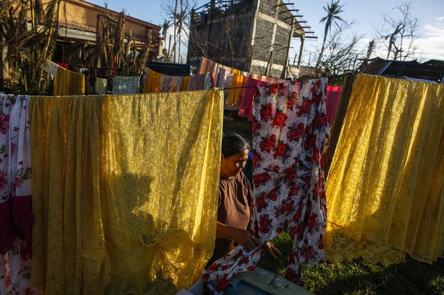 Bà Nelia Llego phơi quần áo tại một khu dân cư bị siêu bão Haiyan tàn phá ở thành phố Tacloban, Philippines.