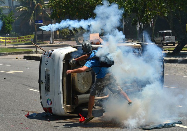Những người biểu tình đụng độ với cảnh sát chống bạo động trước khách sạn Windsor ở Rio de Janeiro, Brazil.