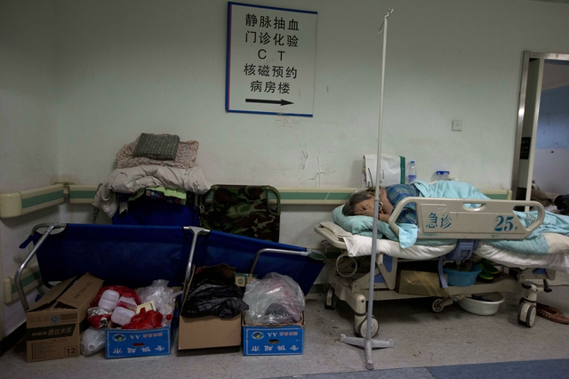 Bệnh nhân phải nằm trên giường ngoài hành lang tại một bệnh viện quá tải ở Bắc Kinh, Trung Quốc.